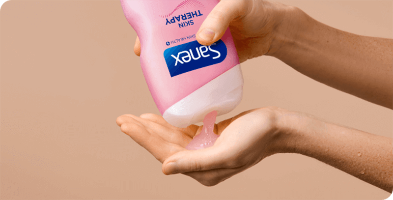 woman using sanex skin therapy atopic shower cream