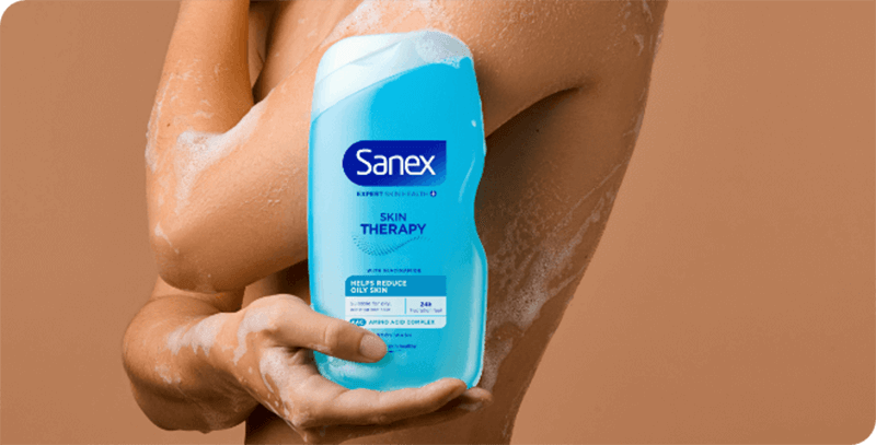 woman using sanex skin therapy oily shower cream