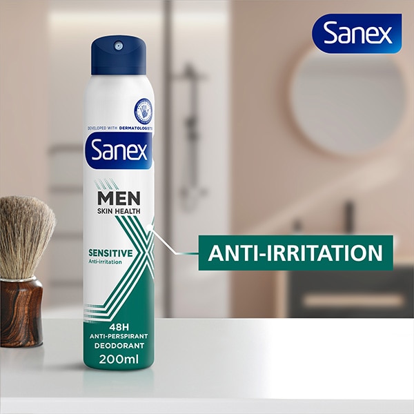 Sanex Men Skin Health Sensitive Antiperspirant Spray sat on table beside shaving brush.