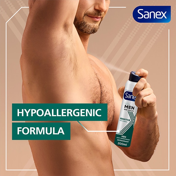 A man using Sanex Men Skin Health Sensitive Antiperspirant Spray on his right armpit.