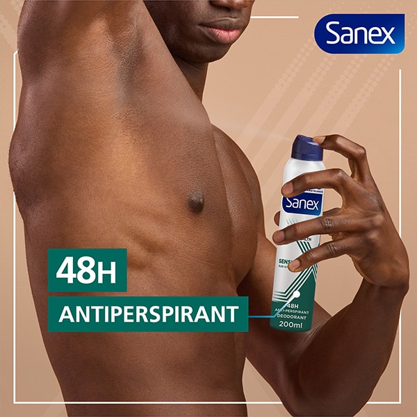 A man using Sanex Men Skin Health Sensitive Antiperspirant Spray on his right armpit.
